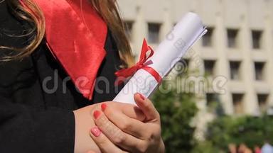女子身着毕业礼服，手持<strong>毕业证</strong>书，展望幸福的未来